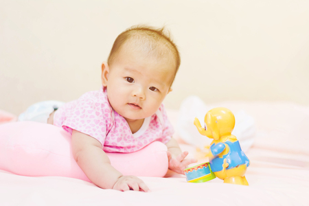Cute adorable newborn baby playing on colorful toyの写真素材