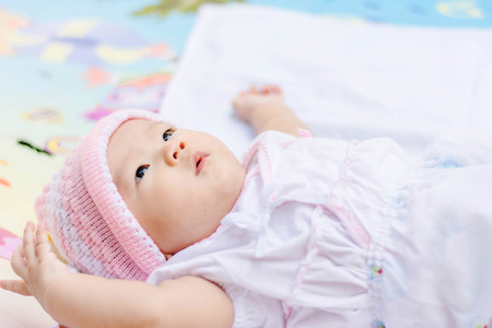 cute Asian baby lie on ground at parkの写真素材