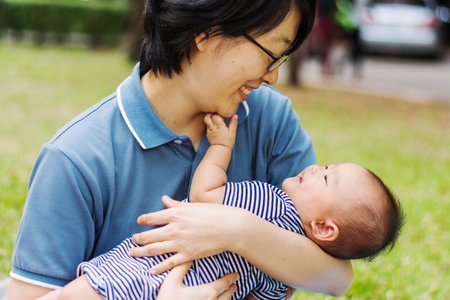Asian mother parenting baby on park