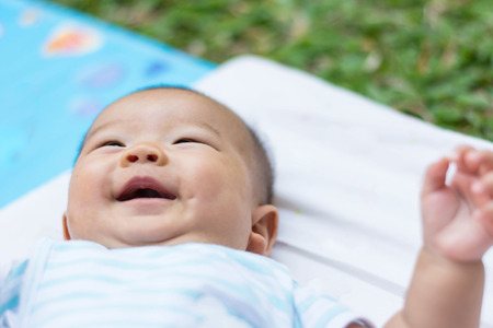 cut Asian baby lie on ground with smilling on faceの写真素材