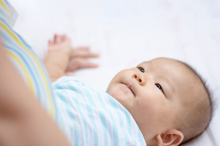 cut Asian baby lie on ground at parkの写真素材