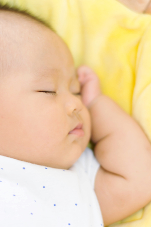 sweet asian baby sleeping  on bed at homeの写真素材
