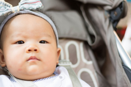 cute and sweet Asian  baby sitting on stroller carriage