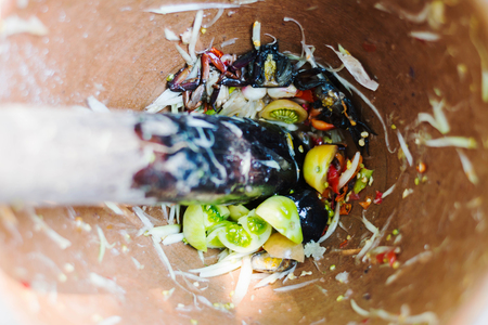 making of green papaya salad, som tam, thai food, ingredients are mixing and pounding in a mortar.の写真素材