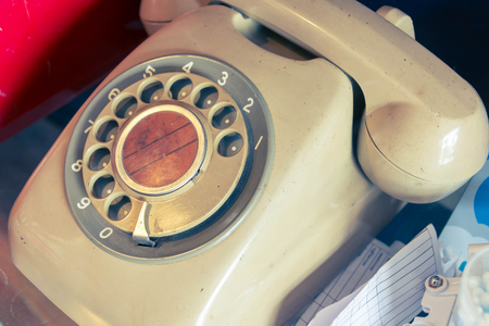 an old telephone with rotary dial on glass cabinetの写真素材