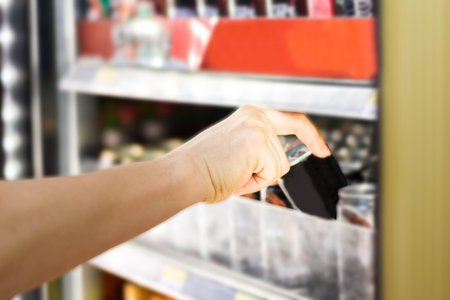 woman's hand open convenience store refrigerator shelves and pick productの写真素材
