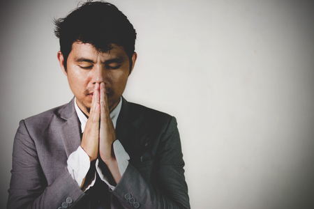 Portrait of a depress business mature man praying in the darkの写真素材