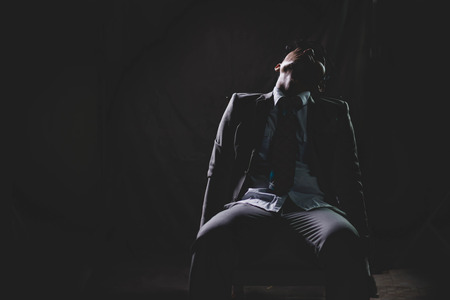 Exhausted and tired of Asian Businessman from overwork, siting and sleep on chair in the dark . の写真素材