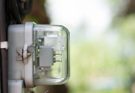 Kilowatt hour electricity meter, power supply meter, hour symbol and measuring dial install on poleの写真素材