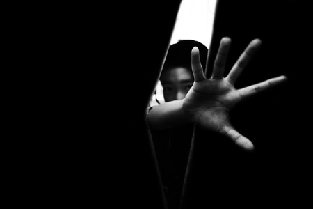fear girl hiding in closet with hand reaching out  in white toneの写真素材