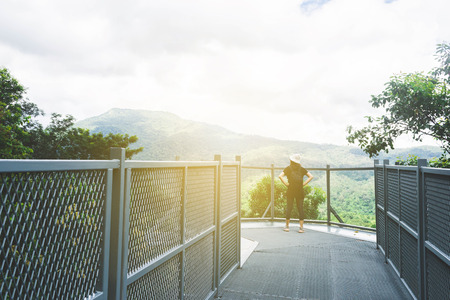 View of young woman standing at the end of walk and enjoy view of  Chiangmai Mountain, Thailand.の写真素材