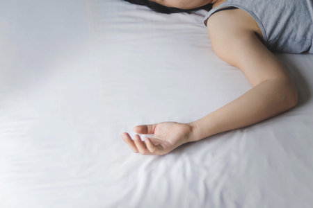 hand of depress and hopeless woman laying on bed with absent mindedの写真素材