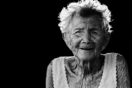 Portrait of  depress and helpless elderly woman, grandma sitting outdoor waiting for children come back home in wihite toneの写真素材