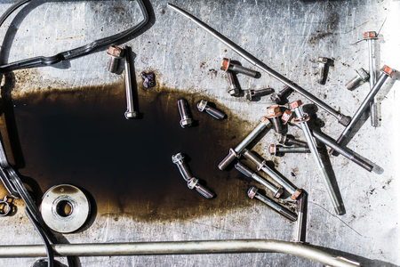 bolt nut of car engine on steel plate with engine oilの写真素材