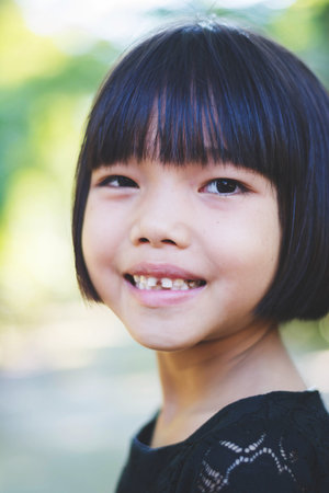 Portrait of Happy Asian girl smiling out door in forest