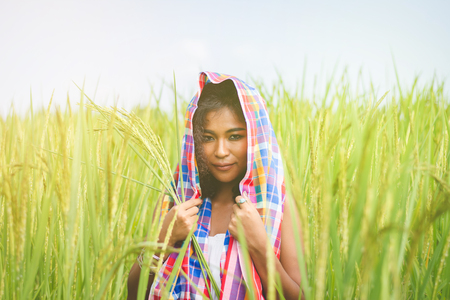 Happy Asian girl enjoy in green rice field, countryside of Thailand at sunset の写真素材