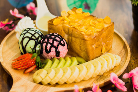 honey toast with ice cream; whipped cream, fruits and almond sliceの写真素材