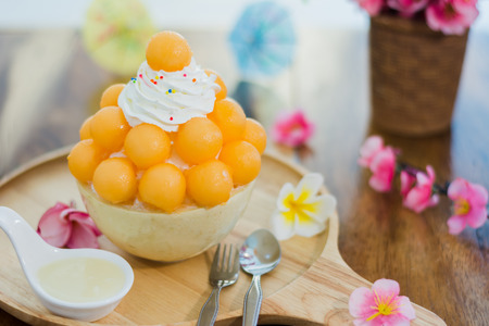 Closeup cantaloupe Bingsu on tray, Bingsu or Bingsoo, Korean shaved ice dessert with sweet toppings and fruit and varieties with ingredients,  popular dessert.の写真素材