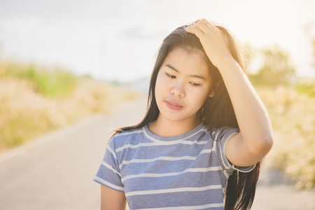 Portrait  beautiful Asian woman in depression and frustration sitting on roadの写真素材