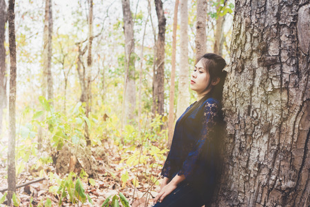 portrait of depress and hopeless young woman calm herself in forest at countryside の写真素材