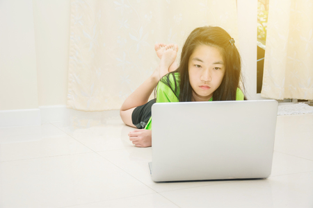 kids doing homework together with laptop at homeの写真素材