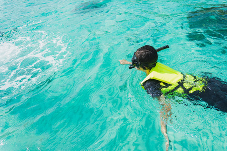 portrait of an asian snorkeling girl with mask swiming on the seaの写真素材