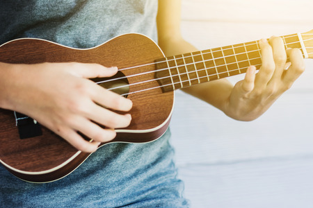 Asian girl enjoy practice guitar at homeの写真素材
