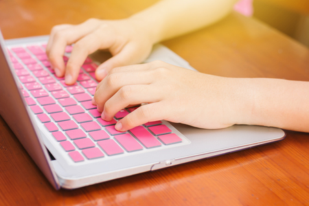 Cute Asian young girl doing homework with laptop at home の写真素材