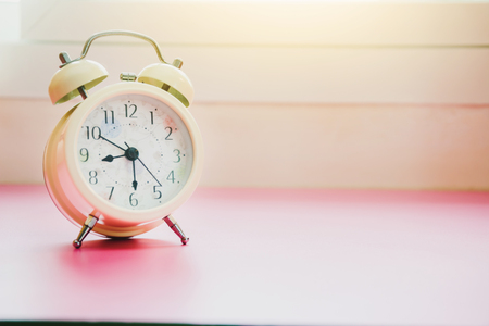 Retro alarm clock with bell on tableの写真素材