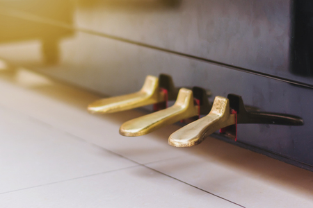 golden piano pedals of piano standing on floor with gradienの写真素材