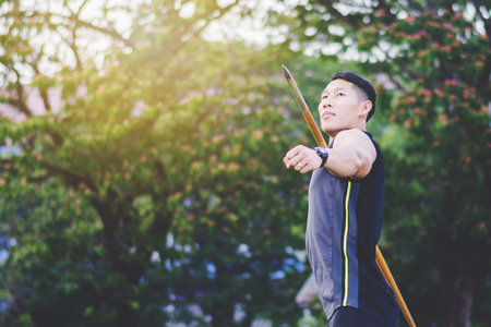 sportsman warming up and practicing javelin throw in yard