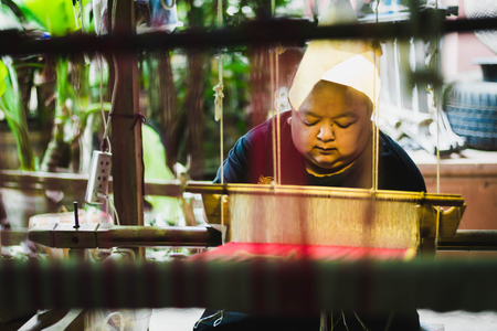 Thai woman making silk thread. A traditional way of hand made silk production.の写真素材