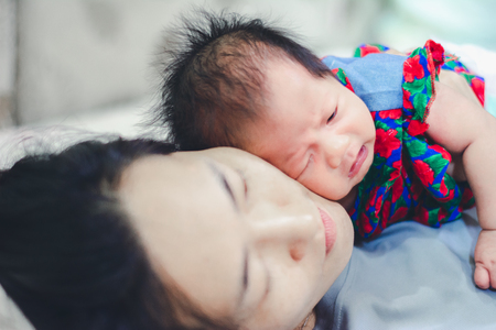 Baby Girl sleep with Aunty at homeの写真素材