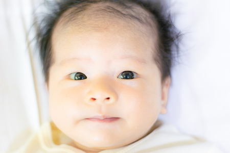 Baby girl in clean cloth lay down on bed after finish showerの写真素材