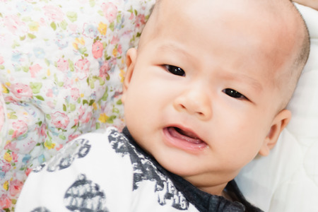 Closeup of happy little child playing over the bed in a relaxed morning with her little baby sister.の写真素材