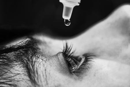 Boy dropping eye drop medicine healing his eye pain, health care eye medicine conceptの写真素材