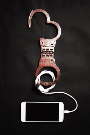 Smart phone with handcuff in the dark, Smart phone addiction concept