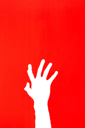 human's hand reaching out for help on red background, Help Needed conceptの写真素材