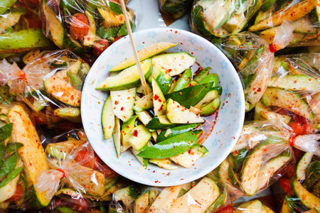 Thai spicy mango salad in bowl and in plasctic packaging selling at morning marketの写真素材