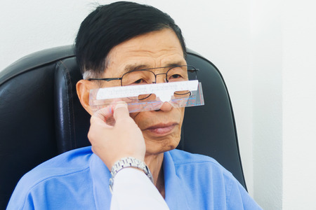 The ophthalmologist determines the distance centers of the lenses with ruler tool. Optician measuring and preparing glassesの写真素材