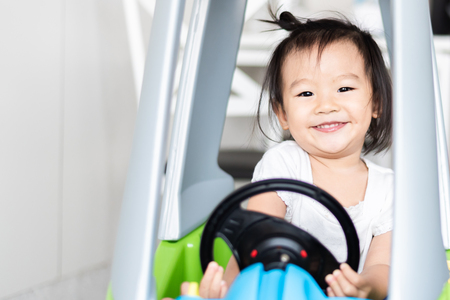 Happy Sweet Little Asian girl riding on small carの写真素材