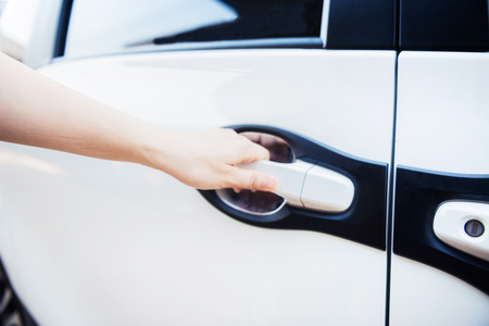 Hand of woman holding handle of car's door, to open car's doorの写真素材