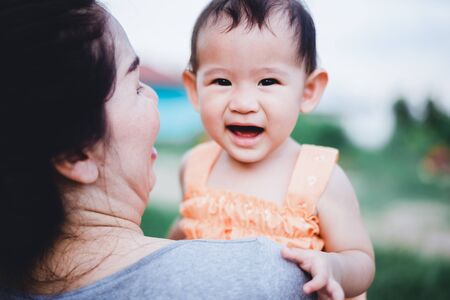 Mother raised her litlle baby on her shoulderの写真素材