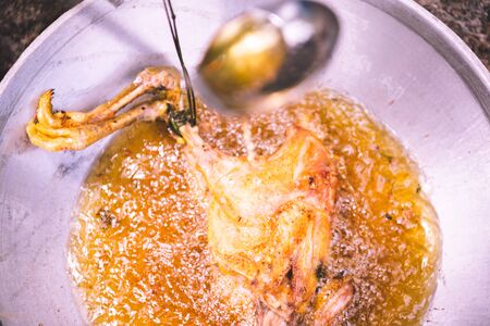 Frying chicken in frying pan with fully oil, cooking conceptの写真素材