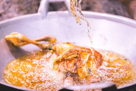Frying chicken in frying pan with fully oil, cooking conceptの写真素材