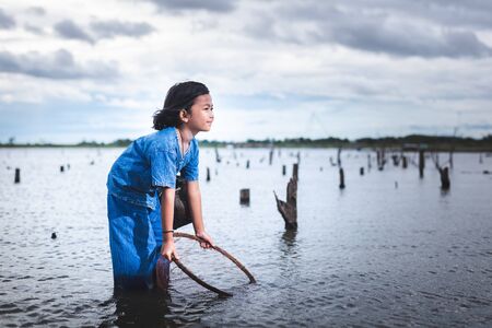 Children have fun fishing in lakel. Life style of children in countryside of Thailand.の写真素材
