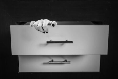 Horror shoot, hand of woman out from drawer in whit toneの写真素材