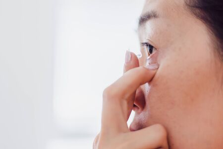 Contact Lens For Vision. Closeup Of Asian woman With Applying Contact Lens On Her Brown Eyes. Beautiful Woman Putting Eye Lenses With Handsの写真素材