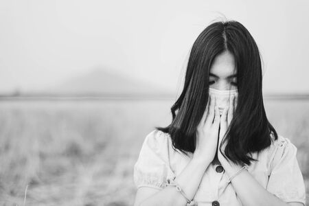 Girl with mask to protect her from Corona virus in white toneの写真素材