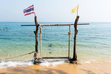 wooden swing and calm sea, Tropical beach sunrise の写真素材